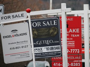 A row of three real estate for sale signs.