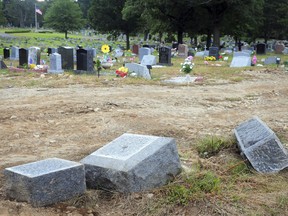 FILE - In this Oct. 2, 2018 file photo, toppled headstones rest on the ground in Park Cemetery in Bridgeport, Conn. A mass desecration of graves at the Connecticut cemetery has devastated dozens of families while police determine whether to file criminal charges. Authorities say gravestones and human remains at the cemetery were moved to make way for the newly dead.