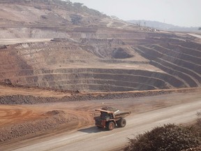 A Caterpillar Inc. mining truck drives past an open pit excavation at the Mutanda copper and cobalt mine in Mutanda, Katanga province, Democratic Republic of Congo, on Wednesday, Aug. 1, 2012.
