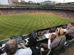 FILE - In this Aug. 3, 2014, file photo, ESPN television broadcasters prepare to cover a baseball game between the New York Yankees and the Boston Red Sox from the top of the Green Monster at Fenway Park, moments before the game, in Boston. ESPN plans to announce it will move up the starting time of the nationally televised game by one hour, with the first pitch planned for shortly after 7 p.m. EDT. The network intends to make the announcement on Monday, Dec. 10, 2018, at the winter meetings, a person familiar with the decision told The Associated Press. The person spoke on condition of anonymity Sunday because the announcement had not yet been made.