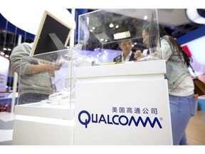 FILE - In this Thursday, April 27, 2017 file photo, visitors look at a display booth for Qualcomm at the Global Mobile Internet Conference (GMIC) in Beijing. U.S. chipmaker Qualcomm says it's won an order in a Chinese court banning some Apple phones in China as part of a long-running dispute over patents. Qualcomm said Monday, Dec. 10, 2018, that the Fuzhou Intermediate People's Court in China has granted preliminary injunctions ordering four Chinese subsidiaries of Apple to stop selling and importing iPhones 6S through X.