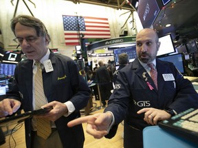 James Denaro, right, talks stock prices at the New York Stock Exchange, Monday, Dec. 10, 2018.