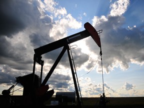 A pumpjack is silhouetted in front of dramatic clouds outside of La Glace, Alberta.