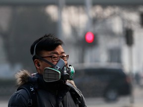 A man wearing a mask walks on a street in Beijing as the capital of China is covered by heavy smog.