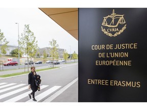 In this photo taken on Monday, Oct. 5, 2015 a woman walks by the entrance to the European Court of Justice in Luxembourg. The European Union's top court ruled Monday, Dec. 10, 2018, that Britain can change its mind over Brexit, boosting the hopes of people who want to stay in the EU that the process can be reversed.