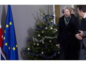 British Prime Minister Theresa May, center, walks past a holiday tree as she leaves the Europa building after a meeting with European Council President Donald Tusk in Brussels, Tuesday, Dec. 11 2018. Top European Union officials on Tuesday ruled out any renegotiation of the divorce agreement with Britain, as Prime Minister Theresa May fought to save her Brexit deal by lobbying leaders in Europe's capitals.