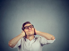 stressed man covering ears looking up stop noise