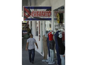 A sign in Spanish that makes a play on words by combining the words "Cuban" and "Cheap" hangs outside a duty free shop in the Colon Free Trade Zone in Colon City, Panama, Friday, Dec. 7, 2018. The Colon Free Trade Zone has a "Little Havana" where Cubans spent $308 million in 2017, and are on track in spend perhaps 8 percent more in 2018, said Luis Carlos Saenz, the zone's general assistant manager.