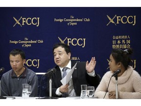 In this Nov. 28, 2018, photo, lawyer Shoichi Ibusuki, center, speaks during a press conference in Tokyo, on the problems in Japan's technical intern program, with Eng Pisey, right, Cambodian technical trainee and Huang Shihu, left, Chinese technical trainee in Tokyo. Ibusuki, lawyer specializing in labor cases and supporting victimized foreign students and interns, called the internship program as a disguise to use trainees as mere cheap labor and should be scrapped and replaced with the new program underway. Japan is set to approve legislation that would officially open the door to foreign workers to do unskilled jobs and possibly eventually become citizens. Lawmakers were due to vote Friday, Dec. 7, on a government proposal to allow hundreds of thousands of foreign laborers to live and work in a country that has long resisted accepting outsiders.