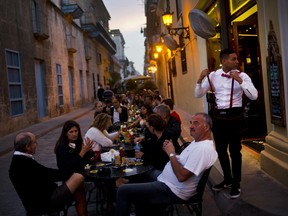 FILE - In this Jan. 31, 2018 file photo, patrons fill the outdoor seating area of a private restaurant in Havana, Cuba. Cuba's government modified in December 2018 a series of measures unpopular with the country's private sector, including lifting restrictions on the number of business permits a person can have and the number of chairs there can be in restaurants.