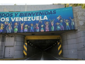 A banner carries the Spanish message: "Welcome to Venezuela" at the entrance of a tunnel along the road that connects La Guaira, where the Simon Bolivar international airport is located, with Caracas, Venezuela, Friday, Jan. 25, 2019. The Venezuelan opposition leader who has declared himself interim president appeared in public Friday for the first time in days and vowed to remain on the streets to usher in a transitional government, while President Nicolas Maduro dug in and accused his opponents of orchestrating a coup.