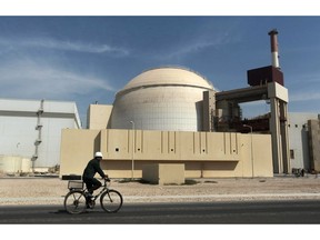 FILE - In this Oct. 26, 2010 file photograph, a worker rides a bicycle in front of the reactor building of the Bushehr nuclear power plant, just outside the southern city of Bushehr. Iran's deputy foreign minister said Thursday, Jan 31, 2019, that he believes European Union nations soon will announce they've created a program for Iran to continue trade there and avoid re-imposed U.S. sanctions over its nuclear program.