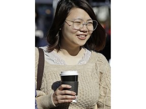 A woman carries a disposable cup Wednesday, Jan. 23, 2019, in Berkeley, Calif. Berkeley has approved a 25-cent tax on disposable cups city officials say is part of an effort to eliminate restaurant waste. The City Council voted unanimously Wednesday to approve the ordinance that also forces restaurants to provide to-go containers that are compostable by January 2020.