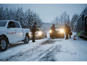RCMP officers switch between shifts near their roadblock as supporters of the Unist'ot'en camp and Wet'suwet'en First Nation gather at a camp fire off a logging road near Houston, B.C., on Wednesday, January 9, 2019.