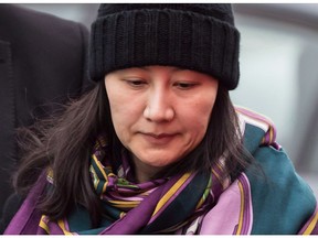Huawei chief financial officer Meng Wanzhou is escorted by her private security detail while arriving at a parole office, in Vancouver, on Wednesday December 12, 2018. American authorities are facing a key deadline at the end of the month to formally request the extradition of Huawei executive Meng Wanzhou from Canada to the United States.
