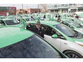 Cab drivers stand beside their new fleet of electric taxis at the launch for Teo Taxi service Wednesday, November 18, 2015 in Montreal. Montreal's Teo Taxi, which sought to take on Uber with a fleet of electric vehicles, has halted operations and laid off all its drivers, a union spokesman says.