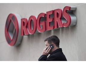 A man speaks on a mobile phone outside Rogers Communications Inc.'s annual general meeting of shareholders in Toronto on April 22, 2014. Two of Canada's largest mobile phone services are being targeted by a social media campaign launched by Remind.com, a San Francisco-based company that provides a free two-way texting service for teachers, students and parents. Remind is calling on its Canadian users -- nearly one million individuals, according to the company -- to pressure Rogers and Bell to reverse a recent price increase that makes Remind's texting service uneconomic in this country.