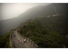 Chinese tourists walk along the Mutianyu section of the Great Wall of China on a foggy day on the outskirts of Beijing, Monday, Sept. 25, 2017. Tit-for-tat travel warnings from Canadian and Chinese governments amid a growing diplomatic rift may be prompting potential tourists into rethinking their vacation plans and hurting the Canadian tourism industry.