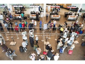 Passengers wait to check-in at Trudeau Airport on July 19, 2017 in Montreal. A passenger rights company says a loophole in proposed regulations could allow airlines get off the hook for compensation and put air travellers at risk. AirHelp notes in an open letter to the government that the rules impose no obligation on airlines to pay customers for delays or cancellations if they were caused by technical problems discovered on the tarmac.