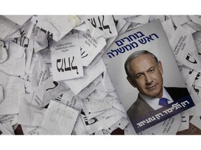 FILE - In this Wednesday, March 18, 2015 file photo, an election campaign poster with the image of Israeli Prime Minister Benjamin Netanyahu lies among ballot papers at his party's election headquarters, in Tel Aviv. Israel's Shin Bet security service says it's able to thwart any foreign intervention in the country's upcoming elections in April 2019, after its director warned of such efforts. (
