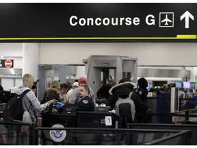 A Transportation Security Administration officer works at the entrance to Concourse G at Miami International Airport, Friday, Jan. 11, 2019, in Miami. The airport is closing Terminal G this weekend as the federal government shutdown stretches toward a fourth week because security screeners have been calling in sick at twice the airport's normal rate.