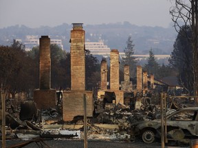 FILE - This Oct. 13, 2017 file photo shows a row of chimneys standing in a neighborhood devastated by the Tubbs fire near Santa Rosa, Calif. Investigators say the deadly 2017 wildfire that killed 22 people in California's wine country was caused by a private electrical system, not embattled Pacific Gas & Electric Co. The state's firefighting agency said Thursday, Jan. 24, 2019, that the Tubbs Fire started next to a residence. They did not find any violations of state law.