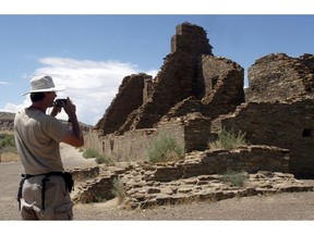 FILE - In this Aug. 10, 2005, file photo, tourist Chris Farthing from Suffolks County, England, takes a picture while visiting Chaco Culture National Historical Park in northwestern New Mexico. The Bureau of Land Management has rescheduled an oil and gas lease sale for March 28, 2019, that includes several parcels that are within 10 miles of the park. The agency says the sale was pushed back to accommodate a public protest period that was delayed due to the recent government shutdown.