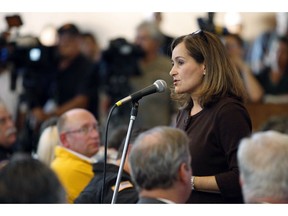 FILE - In this Sept. 11, 2010, file photo, Geisha Williams, right, then-senior vice president of energy delivery for Pacific Gas & Electric, speaks to hundreds of displaced San Bruno residents that jammed a town hall meeting at St. Roberts Catholic Church in San Bruno, Calif. PG&E said Sunday, Jan. 13, 2019, that CEO Williams was stepping down and that John Simon, the company's general counsel, would serve as interim CEO until a replacement is found.