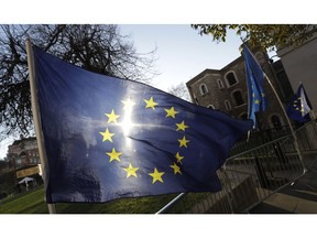 The sun shines through a European Union flag tied onto a railing near parliament in London, Thursday, Jan. 17, 2019. British Prime Minister Theresa May is reaching out to opposition parties and other lawmakers Thursday in a battle to put Brexit back on track after surviving a no-confidence vote.