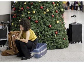 FILE - In this Thursday, Dec. 20, 2018 file photo, a woman waits in the departures area at Gatwick airport, near London, as the airport remains closed after drones were spotted over the airfield last night and this morning. London's Heathrow Airport suspended flight departures as a precaution Tuesday, Jan. 8, 2019 after a reported drone sighting that came just three weeks after a rash of drone sightings shut London's Gatwick Airport.