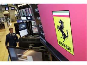 FILE - In this Wednesday, Aug. 1, 2018 file photo, the logo for Ferrari is displayed above a trading post on the floor of the New York Stock Exchange. Italian luxury sports car maker Ferrari says profits last year rose 46 percent, driven by a surge in V12 sales and vehicle personalization. Ferrari on Thursday, Jan. 31, 2019 reported 2018 net profit of 787 million euros ($904 million), up from 537 million euros the previous year.