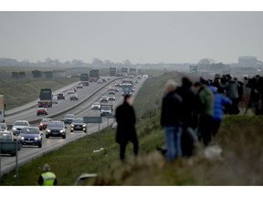 Members of the media watch as some 150 trucks leave Manston Airfield during a 'no-deal' Brexit test for where 6,000 trucks could be parked at the former airfield near Ramsgate in south east England, Monday, Jan. 7, 2019.  The former airfield at Manston could be used to park some 6,000 trucks to alleviate expected congestion at the channel ports, about 25 miles (40 Km) from the airfiled, caused by the reintroduction of customs checks on goods in the event of Britain making a no-deal withdrawal from the European Union at the end of March.