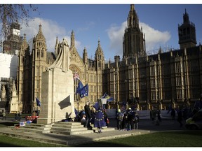 Pro-Europe demonstrators hold banners and flags outside the Houses of Parliament in London, Tuesday Jan. 8, 2019. The British government on Tuesday ruled out seeking an extension to the two-year period taking the country out of the European Union ahead of a crucial parliamentary vote next week on Prime Minister Theresa May's Brexit deal.