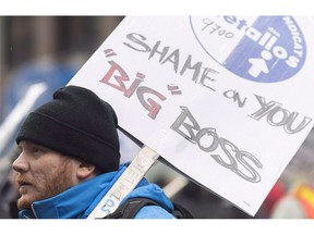 A member of a Steelworkers Union holds up a sign during a protest in Montreal on November 28, 2018, where he demonstrated against the lockout of workers at an Alcoa smelter plant in Becancour, Que.