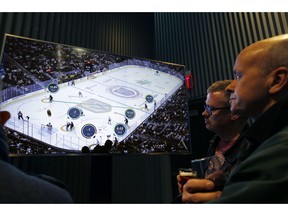 People watch real-time puck and player tracking technology on display during an NHL hockey game between the Vegas Golden Knights and the San Jose Sharks, in Las Vegas, Thursday, Jan. 10, 2019. The NHL for the first time has tested real-time puck and player tracking in regular-season games with the aim of having it ready for the 2019-20 season. Microchips were added to players' shoulder pads and fitted inside specially designed pucks for two Vegas Golden Knights home games this week: Tuesday against the New York Rangers and Thursday against the San Jose Sharks. Antennas stationed around the arena tracked the players and the puck through radio frequencies and beamed the data to a suite where league and Players' Association executives and representatives from 20 teams and various technology firms, sports betting companies and TV rights holders were on hand for the two nights of testing.
