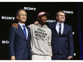 Sony President and CEO Kenichiro Yoshida, left, musician Pharrell Williams, middle, and Sony Music Entertainment CEO Rob Stringer, right, pose for a photograph at the Sony news conference at CES International, Monday, Jan. 7, 2019, in Las Vegas.