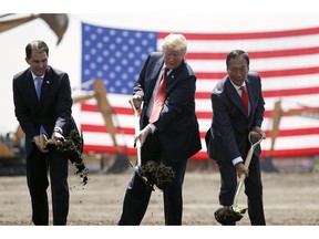 FILE - In this June 28, 2018, file photo, President Donald Trump, center, along with Wisconsin Gov. Scott Walker, left, and Foxconn Chairman Terry Gou participate in a groundbreaking event for the new Foxconn facility in Mt. Pleasant, Wis.  Foxconn Technology Group said Wednesday, Jan. 30, 2019 it is shifting the focus of its planned $10 billion Wisconsin campus away from blue-collar manufacturing to a research hub, while insisting it remains committed to creating 13,000 jobs as promised.