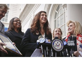 FILE - In this March 27, 2017 file photo "Fearless Girl" statue creator Kristen Visbal, center, speaks after being recognized by U.S. Rep. Carolyn B. Maloney, far right, during a news conference at City Hall in New York.  Visbal is being sued by a group that says she failed to make a 9-foot (2.7-meter) bronze replica of Alexander Hamilton.  U.S. Coast Guard Academy Alumni Association's lawsuit says Kristen Visbal breached a $28,000 contract to create the statue.
