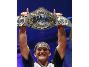 FILE - In this April 21, 2017, file photo, Philippines' Eduard Folayang raises his championship belt during an award ceremony after beating Malaysian-born Ev Ting in the lightweight Mixed Martial Arts title fight dubbed One FC (Fighting Championship), in Pasay city, south of Manila, Philippines. One Championship, the MMA organization out of Asia, is going global in 2019 and it's making the kind of moves that shows it plans to become a player in combat sports.