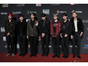 FILE- In this Dec. 14, 2018, file photo members of South Korean music band BTS pose for photos on the red carpet of the Mnet Asian Music Awards (MAMA) in Hong Kong. Mattel has signed a licensing deal with BTS.  Shares surged more than 8 percent in Monday, Jan. 7, 2019, afternoon trading.