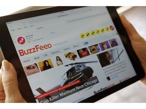 FILE- In this Sept. 2, 2015, file photo the BuzzFeed website is displayed on an iPad held by an Associated Press staffer in Los Angeles. Media company BuzzFeed is cutting 15 percent of its jobs, or about 200 people, to trim costs and become profitable. BuzzFeed CEO Jonah Peretti said in a memo to employees Wednesday, Jan. 23, 2019, that the layoffs will help BuzzFeed avoid having to raise money from investors again.
