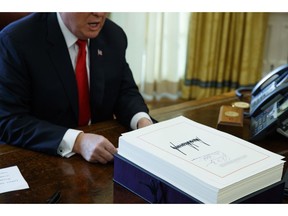 FILE- In this Dec. 22, 2017, file photo President Donald Trump speaks with reporters after signing the tax bill and continuing resolution to fund the government in the Oval Office of the White House in Washington. Millions of small business owners and their tax advisers will be in uncharted waters as they tackle 2018 returns, a new deduction that can exempt one-fifth of owners' business income but that is complex and confusing.