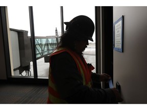 FILE- In this Jan. 23, 2019, file photo Dave McLeod tapes off trim as he prepares to paint a wall near a gate in the new passenger terminal at Paine Field in Everett, Wash. Alaska Airlines says it will delay the start of commercial passenger service at the new terminal by at least three weeks due to the ongoing partial shutdown of the federal government, as the officials who must sign off on a final environmental assessment are on furlough.