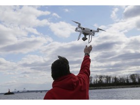 FILE - In this April 29, 2018, file photo, a drone operator helps to retrieve a drone after photographing over Hart Island in New York. Drone sightings reported by airline pilots over New Jersey renew questions about how to accommodate the popular devices into the nation's airspace. The ability of drones to interfere with aviation is likely to get worse as the number of machines multiplies. Many store-bought drones come with technology to prevent owners from flying them near airports, but there are hacks, and home-built machines don't necessarily include those protections.