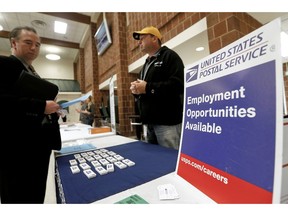 FILE - In this Nov. 2, 2017, file photo a recruiter from the postal service, right, speaks with an attendee of a job fair in the cafeteria of Deer Lakes High School in Cheswick, Pa. U.S. employers likely kept adding jobs at a healthy pace in January even in the face of threats ranging from weakening global growth to the Trump administration's trade war with China to the partial shutdown of the government. On Friday, Feb. 1, 2019, the Labor Department will issue the monthly employment report, the first major economic report to cover most of the 35-day shutdown period that ended a week ago.