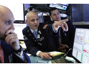 FILE- In this Jan. 4, 2019, file photo Mario Picone, center, works with fellow specialists on the floor of the New York Stock Exchange. The U.S. stock market opens at 9:30 a.m. EST on Monday, Jan. 7.