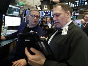 FILE- In this Jan. 18, 2019, file photo specialist Anthony Rinaldi, left, and trader Robert Gasparino work on the floor of the New York Stock Exchange. The U.S. stock market opens at 9:30 a.m. EST on Tuesday, Jan. 22.