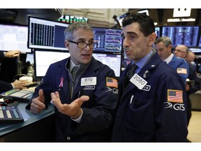 FILE- In this Jan. 4, 2019, file photo specialists Anthony Rinaldi, left, and Peter Mazza confer as they work on the floor of the New York Stock Exchange. The U.S. stock market opens at 9:30 a.m. EST on Friday, Jan. 11.