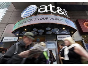 In this Oct. 21, 2014 file photo, people pass an AT&T store in New York's Times Square. AT&T says it will stop selling customer location data to data brokers, as the telecom industry faces backlash that the data has been used improperly. The company says it will eliminate even the kind of selling it calls helpful for consumers. Last year, AT&T pledged to stop providing location information to data brokers. But it kept selling to some services such as those that help with roadside assistance. That will end by March 2019.