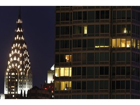 FILE - This May 14, 2015 file photo, shows the top of New York's iconic Chrysler Building, left, in a night view of Manhattan. The owners of the Art Deco skyscraper are putting it on the market. The Abu Dhabi Investment Council and New York developer Tishman Speyer, have hired a commercial real estate firm to market the 77-story landmark building that was constructed between 1928 and 1930 and was the world's tallest building until the Empire State Building claimed the title in 1931.